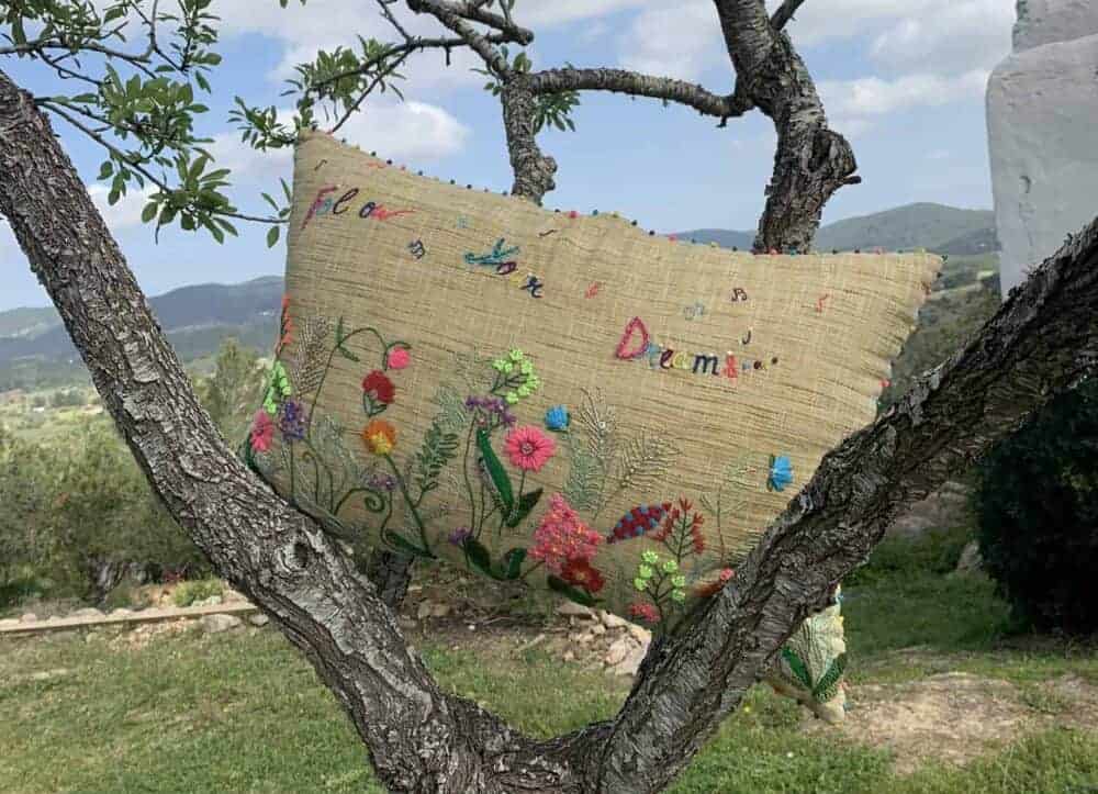an embroidered cushion sitting in a tree